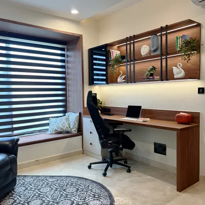 A modern contemporary study room designed for focus and comfort. The space features a custom floating desk with overhead shelves illuminated by LED lighting, an ergonomic chair, and a cozy bay window seat for breaks.