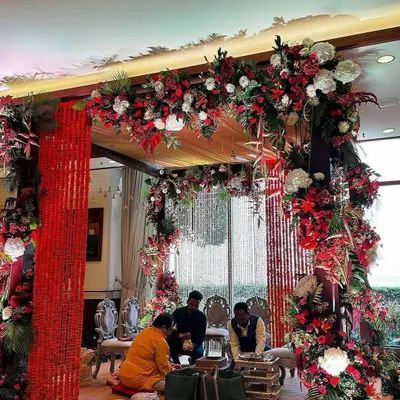 A grand and luxurious wedding mandap decoration. I used a rich combination of red and white flowers, red fabric strings, and elegant seating to create this beautiful ceremony space.