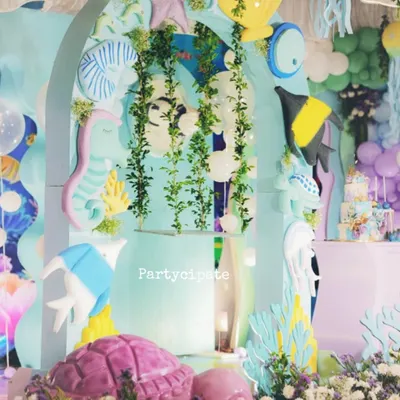 A beautiful, dreamy setup for an 'Under the Sea' party. We used soft pastel colors, hanging greenery, and cutouts of fish, seahorses, and turtles to create a magical ocean scene.