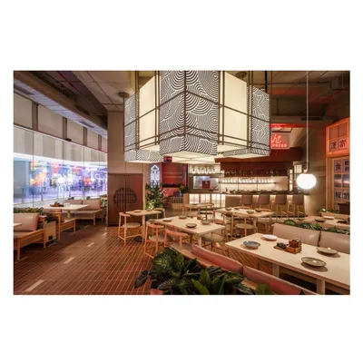 A wide view of the Lucky Chan dining area, showing the interplay between the large, graphic pendant lights and the various seating zones. The design ensures an open feel while maintaining intimate pockets for dining.