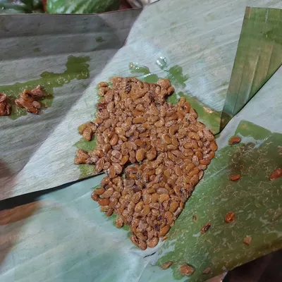 This is Axone, or fermented soybeans, a key ingredient in Naga cuisine. It has a strong, pungent aroma and adds a deep, savoury flavour to pork and fish curries.