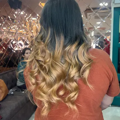 A stunning blonde ombre effect, transitioning from a darker root to bright, beautifully curled ends. This is a perfect example of a high-contrast, expertly blended look.
