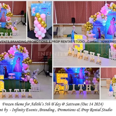 A classic Frozen theme for a fifth birthday at Sattvam. The setup includes a character backdrop with Elsa and Anna, a pink and gold balloon garland, and a light-up number "5".