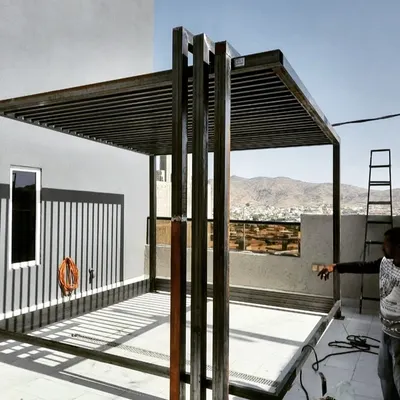 The robust metal frame of a modern pergola being constructed on a rooftop. This image highlights the clean lines and strong structural integrity of our custom-built outdoor shade structures before the final finishing is applied.