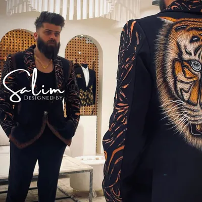 A client admiring his reflection in a custom jacket featuring a large, hand-painted tiger on the back. The design extends to tiger stripes on the sleeves, creating a truly fierce and artistic statement.
