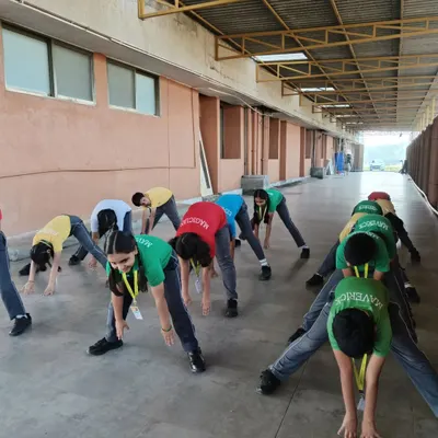 Students at DPS Panvel engage in a group stretching session. Flexibility is a key component of our youth training program, helping to improve range of motion and reduce the risk of injury during play.