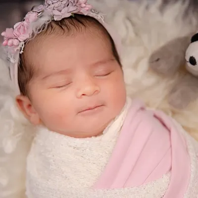 A gentle smile on a sleeping angel's face. This close-up captures the pure bliss and innocence of a newborn's dreams.