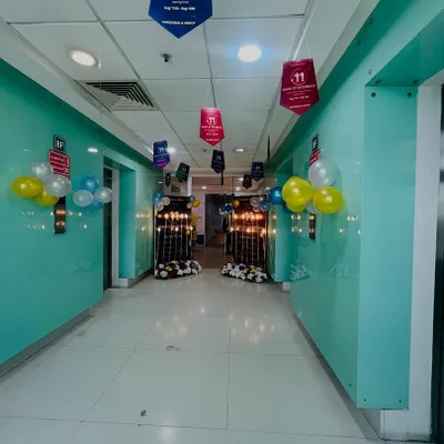 This is a corridor view of an office anniversary celebration I decorated. I used hanging banners and balloon clusters to guide guests towards the main event area.