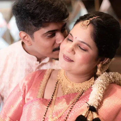 A close-up portrait filled with tenderness from a Godh Bharai celebration. This candid photo captures a sweet kiss and the serene expression of the mother-to-be, adorned in her beautiful traditional jewelry.