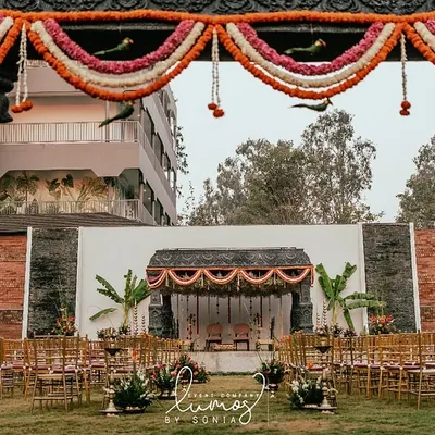 A majestic view of a South Indian temple-style wedding setup, with intricately carved pillars framing the sacred mandap. This design creates a sense of heritage and grandeur for the ceremony.