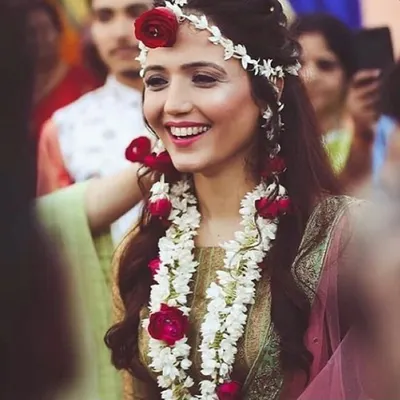 This is a custom floral jewellery set I made for a bride, featuring a maang tikka, necklace, and earrings with white mogra and vibrant red roses. I design these pieces to match your outfit and personal style for any pre-wedding event.