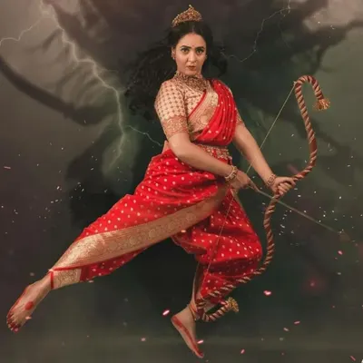 A powerful and dramatic image from our "Navatar" concept shoot. We styled this look using a red Banarasi silk saree draped in a unique warrior style, complete with a bow and arrow for a mythological feel.