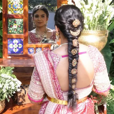 A beautiful back view showcasing the intricate details of this custom blouse. The unique cut and delicate embroidery are perfectly complemented by the traditional braided hairstyle.