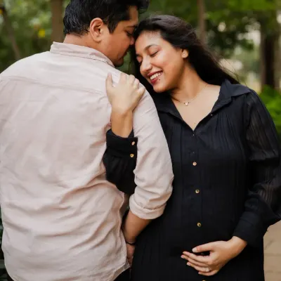 A tender moment between an expecting couple during their outdoor maternity session. The natural setting and their close embrace highlight their connection.