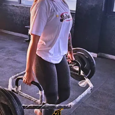 A member performing a hex bar deadlift. This is a fantastic compound movement for building full-body strength and power, safely and effectively.