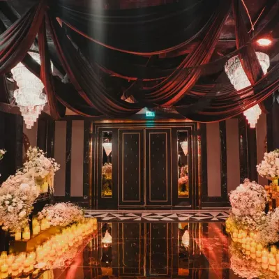 The entrance to the 'City of Dreams' after-party. We used dramatic black drapes, crystal chandeliers, and a candlelit floor to create a grand, immersive entryway for guests.