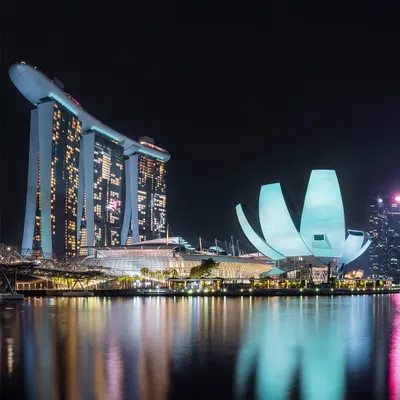 A classic shot of Singapore's Marina Bay Sands and the ArtScience Museum, their iconic structures glowing at night.