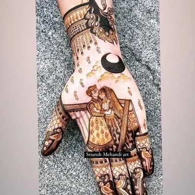 A modern and romantic Karwachauth design. It features a couple embracing under the moon, with a graceful peacock on the wrist. This is a perfect example of telling a story in a smaller space.