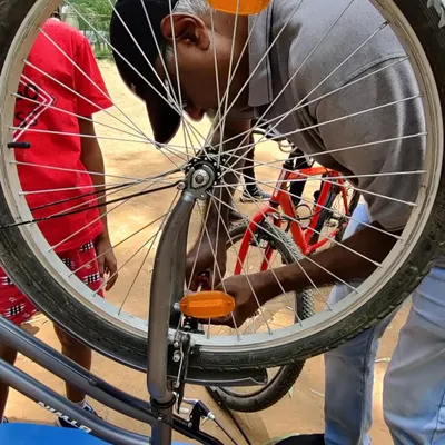 A close-up of a bicycle wheel being serviced at our workshop. We teach the fundamentals of bike maintenance, helping you keep your ride smooth and safe.