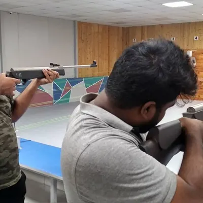 Two guests take aim with their air rifles during a beginner session. Our coaches focus on teaching the correct stance and aiming technique to build a strong foundation.