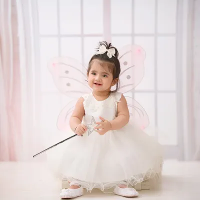 A little fairy in the making. Our studio is stocked with whimsical costumes and props like these wings and wand to create truly magical portraits.