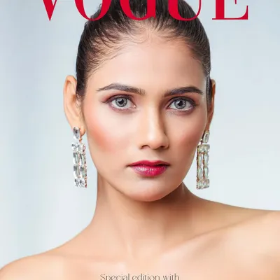A clean, striking beauty shot that could grace any VOGUE cover. The focus is on the model's flawless makeup and captivating eyes, framed by elegant diamond earrings.