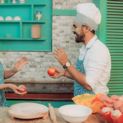 Love is cooking up something beautiful! This couple shares a laugh in a quirky kitchen setting, a perfect example of a themed pre-wedding shoot that reflects shared interests and creates fun, natural interactions.