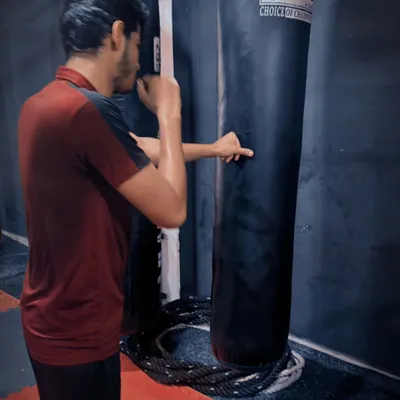 Focused and determined. A student practices his punching technique on the heavy bag, a perfect example of the dedication we cultivate in our fighters.