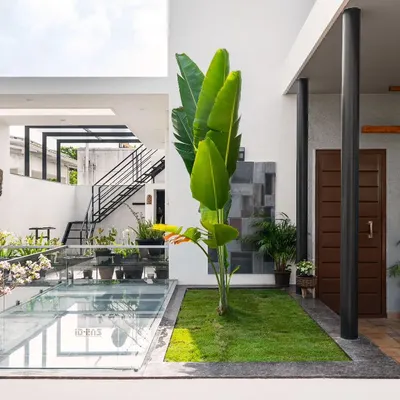 Here, a glass skylight over a portion of the ground floor illuminates the space below while providing a walkable glass floor for the terrace above. This connects two levels of the home with light and greenery.