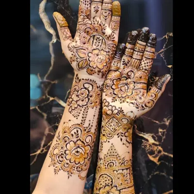 A beautiful designer mehendi with a mix of styles on each hand. One hand has a classic Indian floral pattern, while the other has a more geometric look.