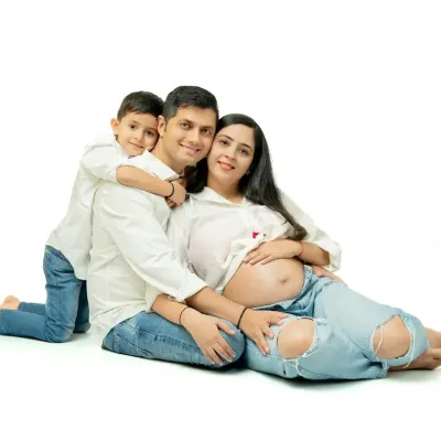 Family maternity sessions are full of joy and real moments. This shot captures the excitement of a big brother-to-be, celebrating the growing family in a relaxed, fun studio setting with casual matching outfits.