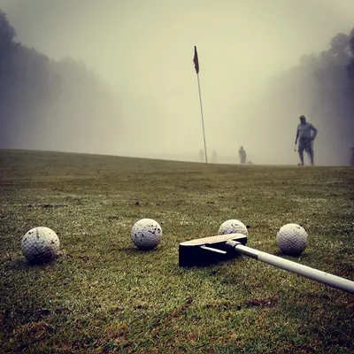 Early morning putting practice on a foggy green. Dedication means showing up and working on your short game, no matter the conditions.