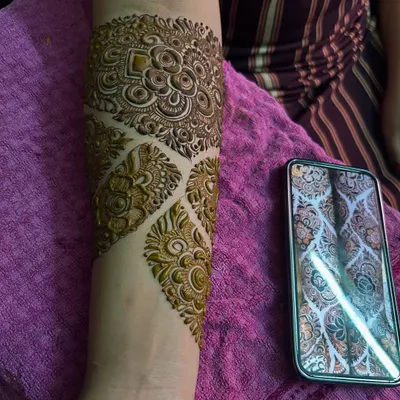A close-up of an engagement mehendi, showing the intricate patterns on the forearm. The design is inspired by a reference photo provided by the client.