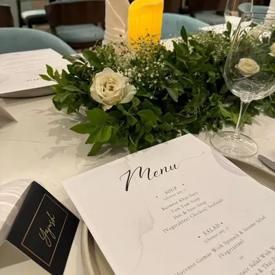 A close-up of a place setting from one of our elegant dinners. We provide custom-printed menus and personalized name cards that perfectly match the event's theme, adding a thoughtful and bespoke touch for every guest.