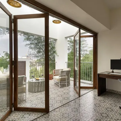 We transformed a laundrette and small balcony into this stunning home office, using a sliding folding door to open the space to a serene, green view.
