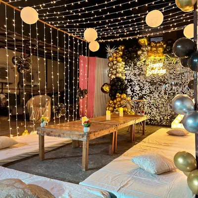 We now offer complete event solutions, including decorations. This beautiful setup features floor seating, fairy lights, and a sequin backdrop, creating a glamorous and comfortable ambiance for a New Year's party or any special occasion.