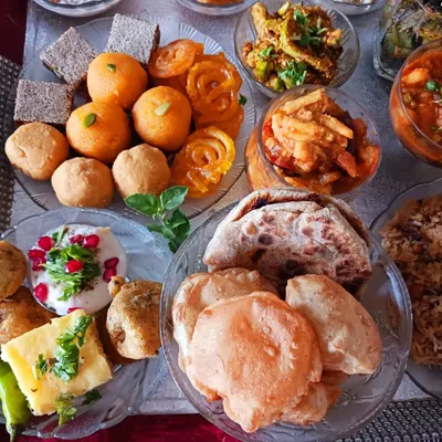 A closer look at the breads and sweets from my vegan 56 Bhog. This platter includes classic Indian sweets like jalebi and laddoos, alongside savory pooris and puranpoli, all made without dairy.
