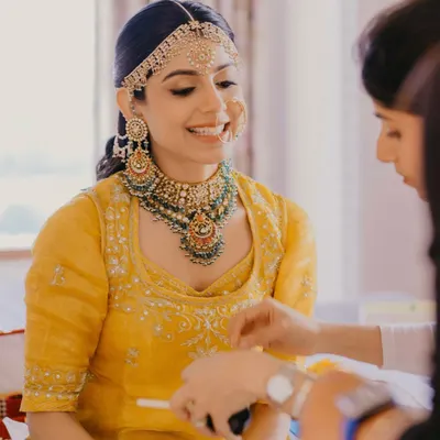 A radiant bride in her grandmother's heirloom yellow poshak for her Udaipur wedding. We kept the makeup minimal and glowing to honor the tradition and the beautiful color.