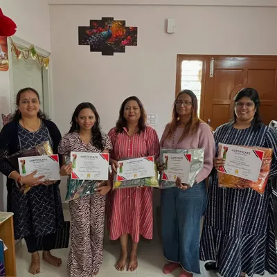 A group of happy students from my Bangalore workshop, proudly holding their certificates and the beautiful sarees they learned to fold.