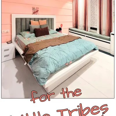 A full view of the renovated girl's bedroom, featuring a custom bed with an upholstered headboard, a cozy window seat with built-in storage, and a soft, warm color scheme.