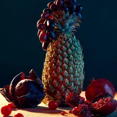 Part of my "Fru-Veg" series, this image is a creative still life experimenting with light and form. I constructed a sculpture using a pineapple, grapes, and a purple cabbage, using dramatic lighting to create a painterly effect.