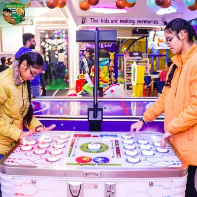 A great action shot of two older kids intensely focused on a fast-paced tabletop arcade game. It's proof that the fun here isn't just for toddlers.