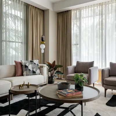 In the living room of Villa 93, we created a sanctuary of calm with a neutral color palette and abundant natural light. The design marries modern furniture with a bold, graphic rug, creating a space that is both sophisticated for entertaining and comfortable for quiet family moments.