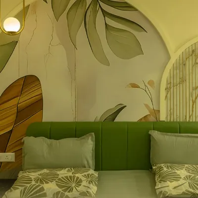 This bedroom features a custom-arched wall mural with a soft, botanical theme. The vibrant green upholstered headboard provides a beautiful contrast, creating a fresh and serene sleeping environment.