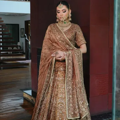 For this look, I personally draped the dupatta to create a royal and elegant silhouette. The rich brown Akriti by Shakun lehenga is perfectly complemented by the heavy polki and emerald jewellery from Shri Paramanijewels.