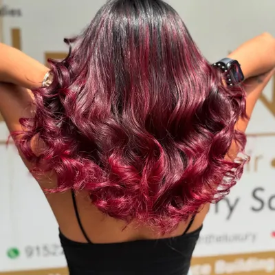 A stunning Redwine Balayage that blends seamlessly from a dark base to vibrant red ends. This look is styled in waves to show off the rich, dimensional colour.