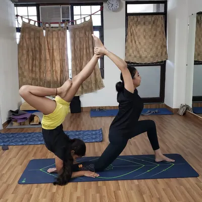 This advanced partner yoga pose combines a forearm stand with a lunge, requiring strength and focus from both students. It is a great way to build communication and teamwork.