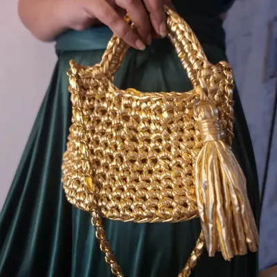 This is my showstopper, the 'Golden Girl' bag. I hand-crochet each one from metallic t-shirt yarn, making it a perfect statement piece for when you want to feel that extra bit of sparkle. It's sturdy, stylish, and made with so much love.