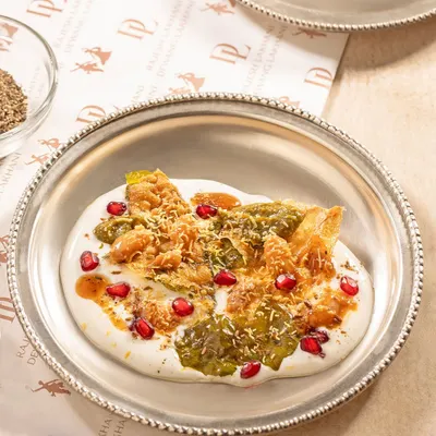 A classic street food favourite, elevated. Our Palak Patta Chaat features crispy fried spinach leaves layered with smooth yogurt, tangy chutneys, and a sprinkle of sev and pomegranate seeds for a burst of flavour and texture.