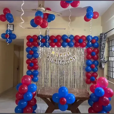 This is an example of a simple and effective home decoration. I used a red and blue balloon frame around a silver shimmer curtain to create a festive photo corner behind the cake table.